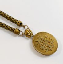 A Victorian oval gold plated locket with intertwined initials set in relief to the front, 3.3cm x