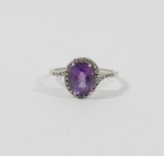 A 9 carat white gold amethyst single stone ring within melee diamond surround and shoulders,