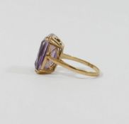 A 9 carat gold amethyst single stone ring, the emerald-cut stone within four double claw settings,