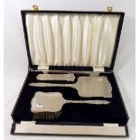 A silver backed dressing table set, comprised of a long handled hair brush, a smaller hair brush,