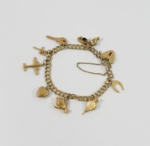 A 9 carat gold charm bracelet, the double curb link bracelet with heart-shaped padlock clasp and 9
