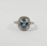 An aquamarine and diamond cluster ring, the mixed-cut cushion-shaped aquamarine approximately 1.85