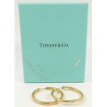 A pair of yellow metal hollow hoop earrings stamped 'TIFFANY' and '14K', 5.8g and a pair of 9