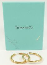 A pair of yellow metal hollow hoop earrings stamped 'TIFFANY' and '14K', 5.8g and a pair of 9