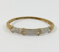 A 9 carat gold hinged bangle, set with eight-cut diamonds, combined weight 0.25 carats, 14.1g gross,