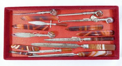 A quantity of banded carnelian handled items comprised of seven paper knives, a button hook, a