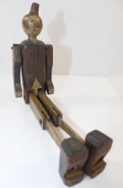 A  scratch built wooden Pinocchio puppet, with hinged arms, legs and feet, 26cm long, with broken