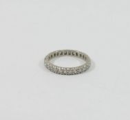 A diamond eternity ring, the unmarked white metal set with approximately 26 eight cut diamonds,