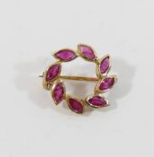 A small circular yellow metal laurel leaf brooch, set with rubies, import marks for London 1989, 1.