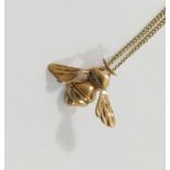 A 9 carat gold bee pendant, London 1983, 2.2cm wide, on chain stamped '9CT', 40.5cm long, combined