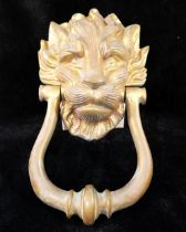 A lion mask brass door knocker, 22cm long, a brass letter box, 23.5cm wide, and a brass dolphin door