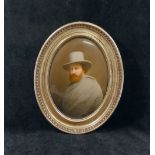 A late 19th century Continental oval porcelain plaque painted with a man wearing a grey cloak and