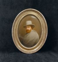 A late 19th century Continental oval porcelain plaque painted with a man wearing a grey cloak and
