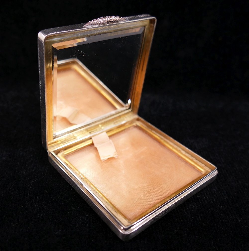 A square silver powder compact, with engine turned decoration, rose coloured thumb piece, and gilt - Image 2 of 3