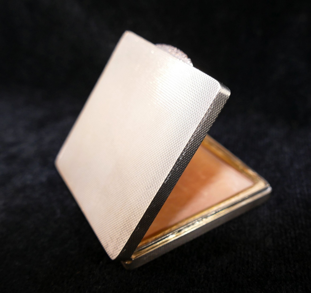 A square silver powder compact, with engine turned decoration, rose coloured thumb piece, and gilt - Image 3 of 3
