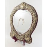 An early 20th century Continental heart-shaped bevelled edge dressing table mirror, within ornate