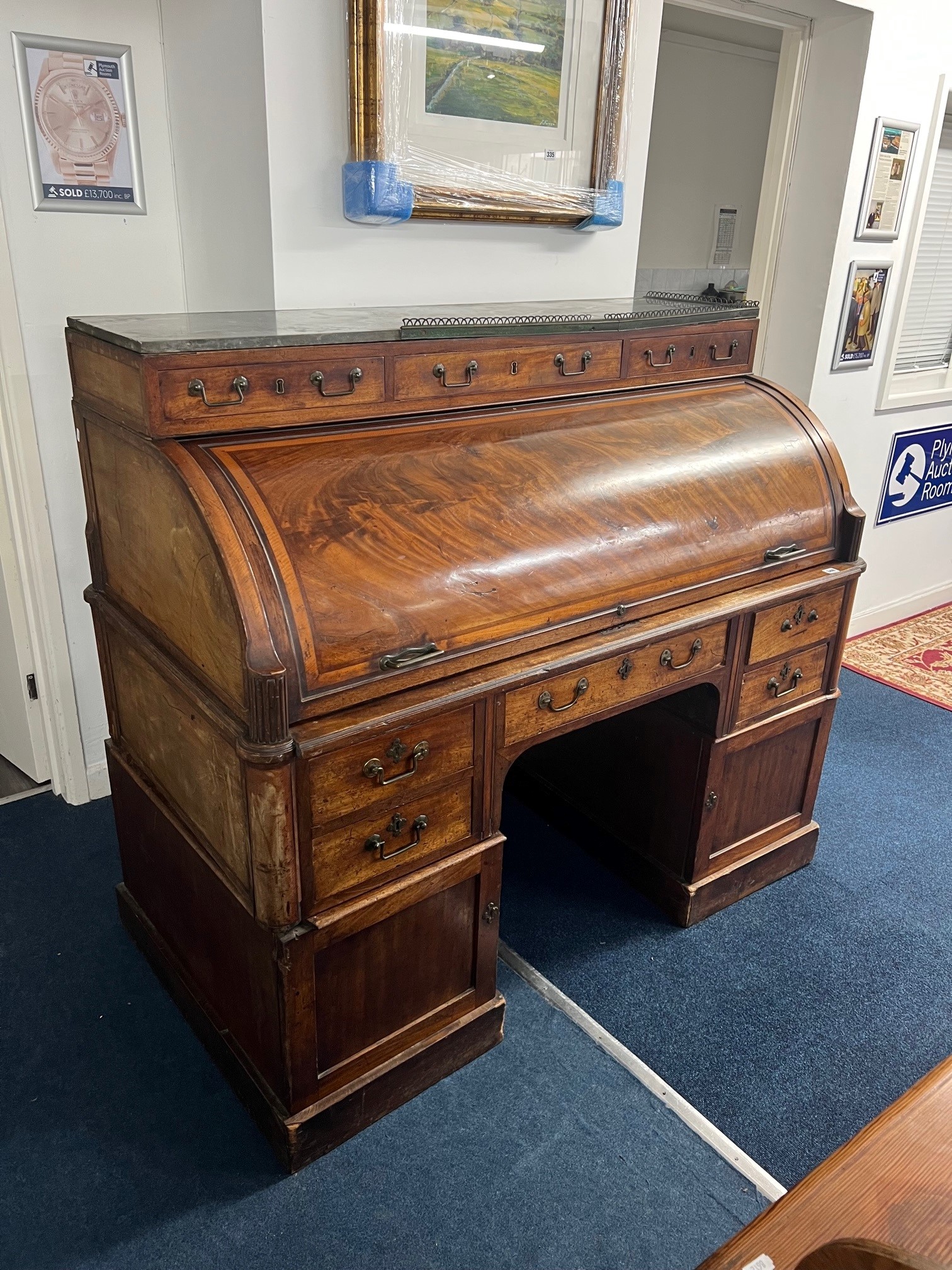 A large Louis XVI style mahogany cylinder bureau fitted with an arrangement of drawers and Pidgeon