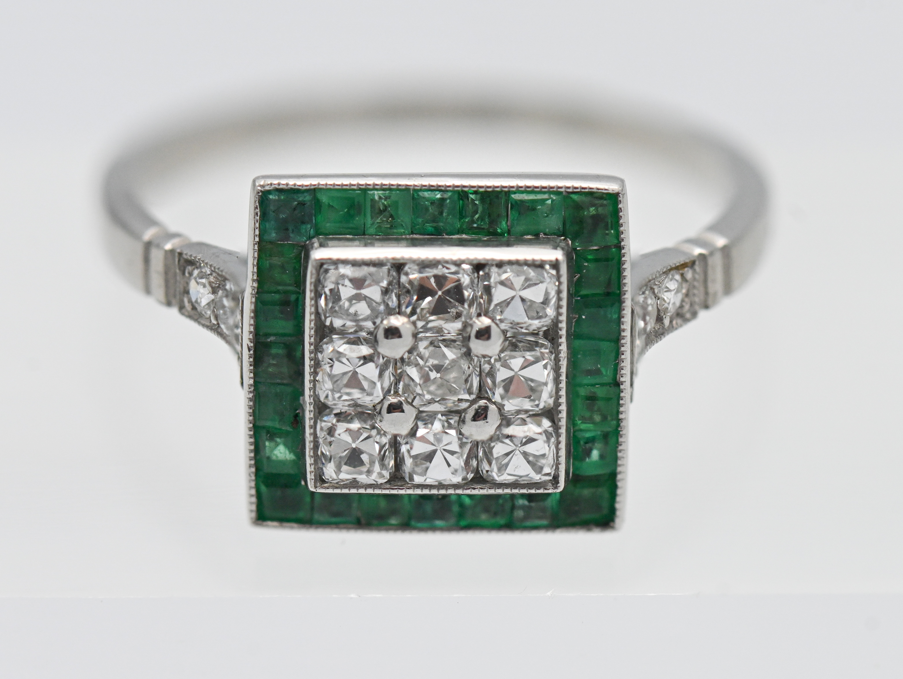 An emerald and diamond art deco square set ring, set in platinum, size N.