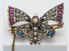 An antique butterfly brooch set with diamonds, ruby's, sapphires and seed pearl.