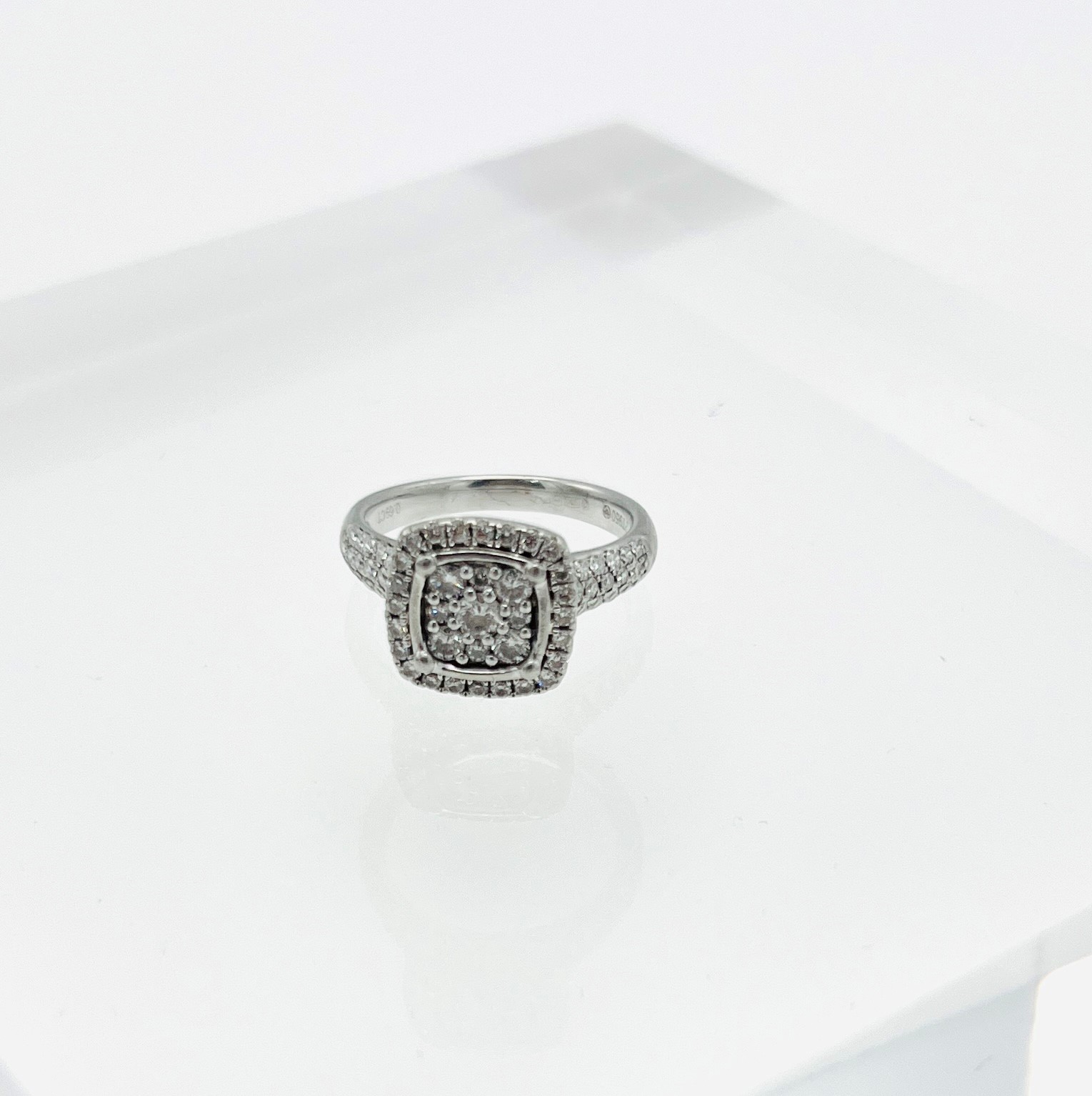 A platinum and diamond cluster ring of square design enhanced with further diamonds to the