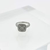 A platinum and diamond cluster ring of square design enhanced with further diamonds to the