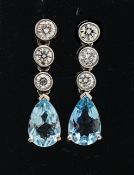 A pair of 18ct white gold three stone diamond and pear shape aquamarine drop earrings