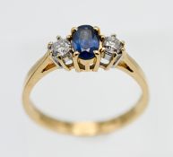 An 18ct yellow gold diamond and sapphire three stone ring, size O.