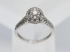 An oval shaped diamond cluster ring, set in 18ct white gold, size R.