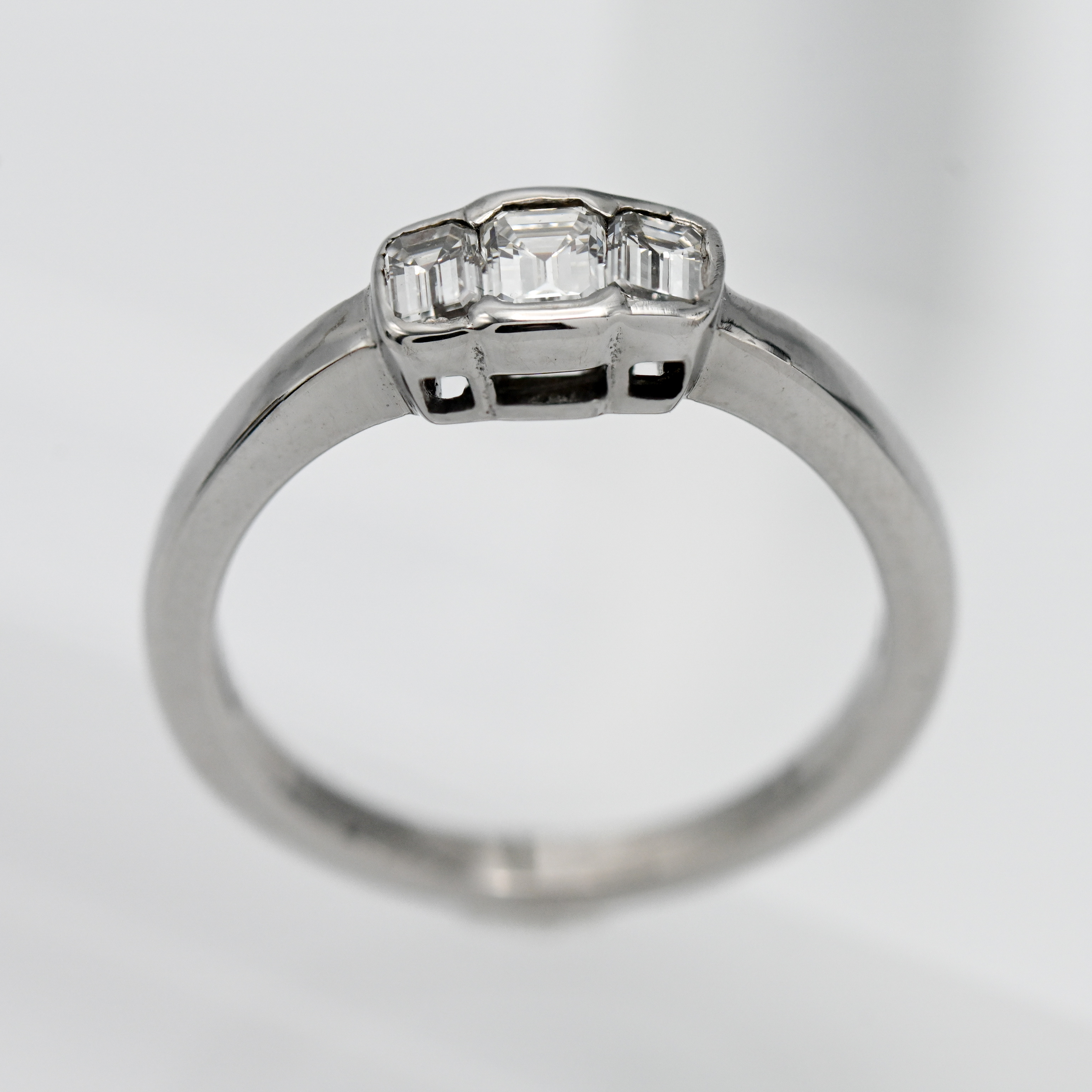 A diamond three stone ring, emerald cut stones, set in 18ct white gold, size M/N.