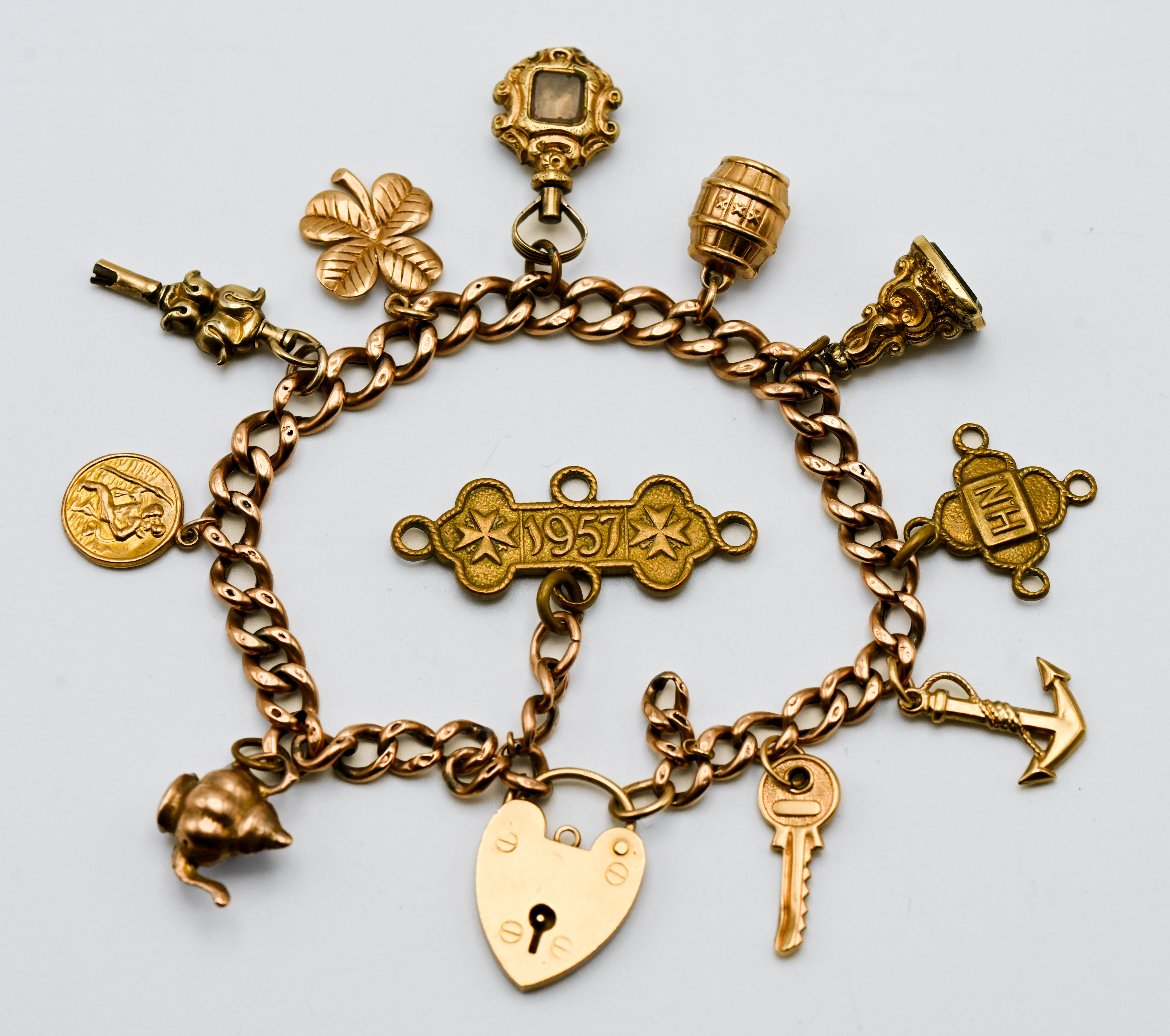 A 9ct gold charm bracelet with eleven charms in total (mainly gold), approx. 30.6g.