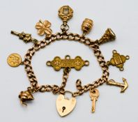 A 9ct gold charm bracelet with eleven charms in total (mainly gold), approx. 30.6g.