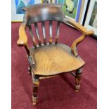 An antique Captain's chair, with elm seat, turned legs and 'H' stretchers.