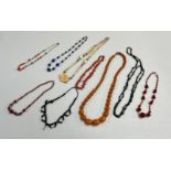 A small collection of dress jewellery including an Amber style bead necklace and other necklaces.