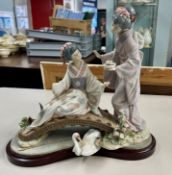 A large Lladro figure group of two women on a bench. (damage thumb missing)