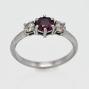 A white gold ruby and diamond three stone ring, centre round cut ruby, with two old cut diamonds