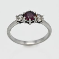 A white gold ruby and diamond three stone ring, centre round cut ruby, with two old cut diamonds