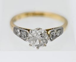 An 18ct gold and platinum diamond ring, set with a central old cut diamond with two old cut diamonds