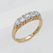 An 18ct yellow gold five stone diamond ring set with old cut diamonds in a scroll head setting, size