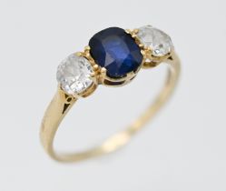 An 18ct yellow gold classic sapphire and diamond three stone ring, centre blue oval shape sapphire