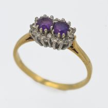 An 18ct yellow and white gold set amethyst and diamond double cluster ring, size S.