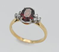 An 18ct diamond and garnet cluster ring. Size Q.