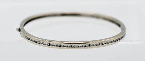 An 18ct white gold and diamond bangle, with copy of receipt from Harvey Nichols dated 2001,