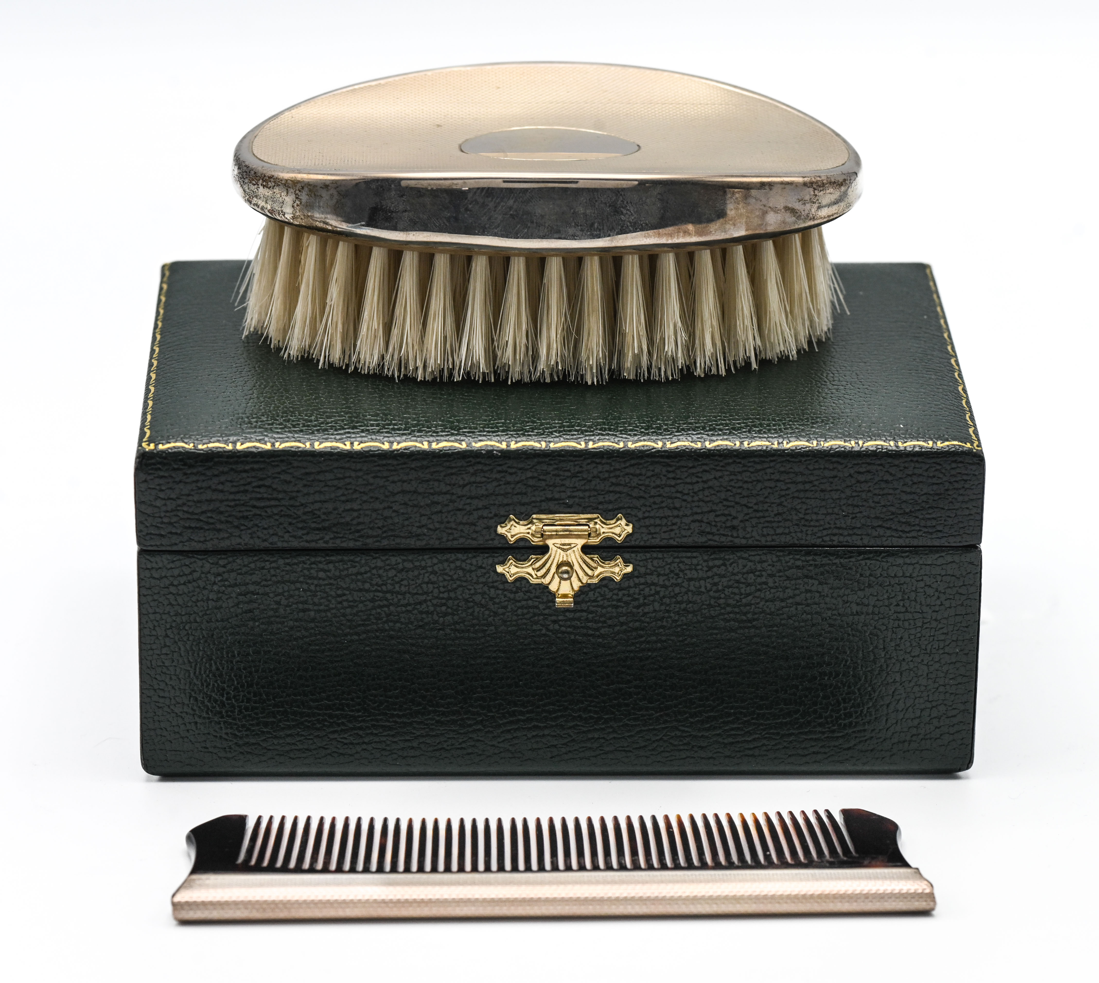 As new green cased grooming set comprising oval silver topped brush and silver spined comb combo -