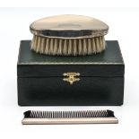 As new green cased grooming set comprising oval silver topped brush and silver spined comb combo -