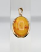 A Honey coloured Baltic amber gold (hallmark 585) pendant with some fossils naturally trapped in the