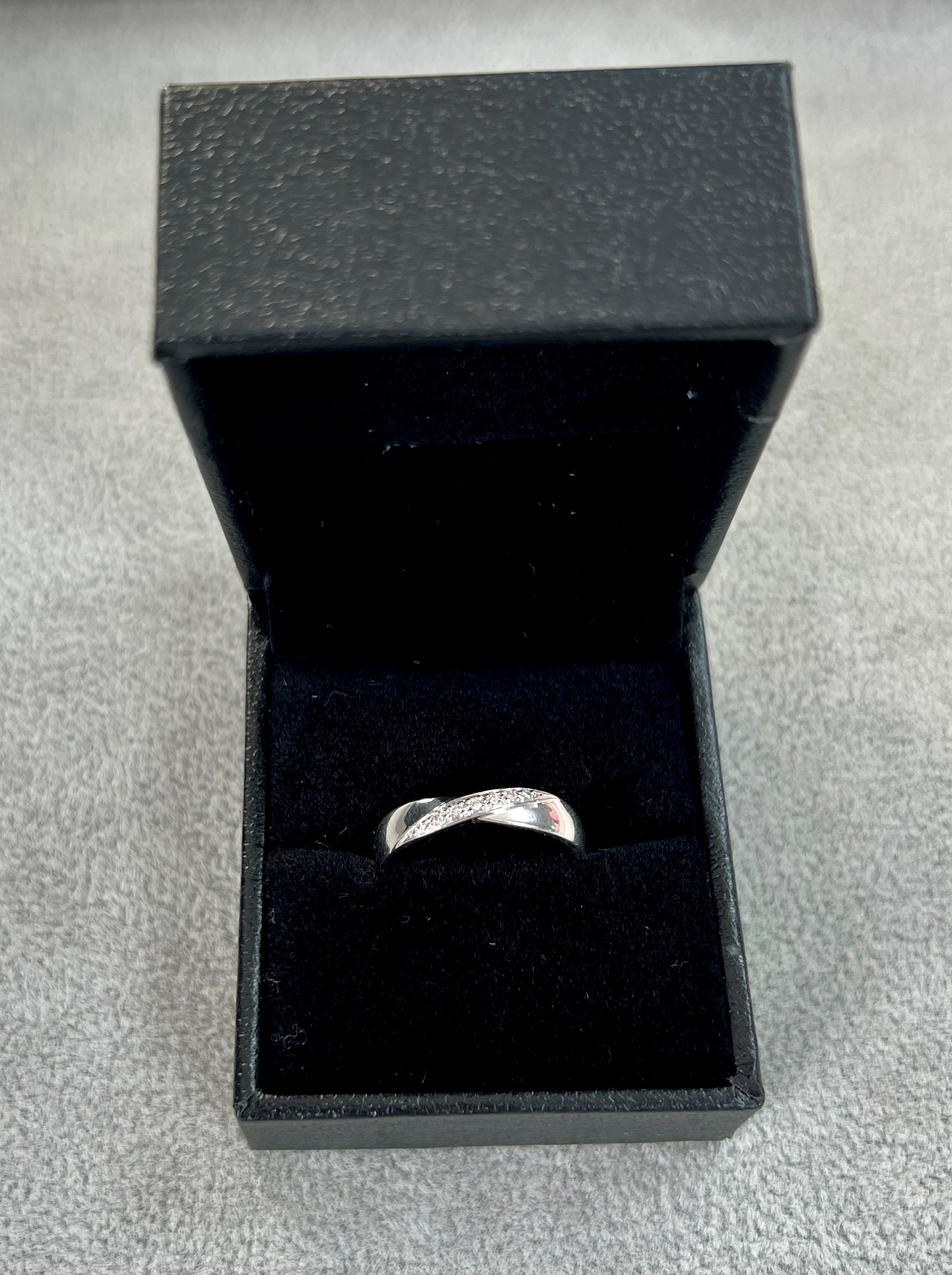 A platinum diamond set 'D shaped' band ring with polished finish. Diagonal stripe with 7 diamonds.