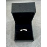 A platinum diamond set 'D shaped' band ring with polished finish. Diagonal stripe with 7 diamonds.