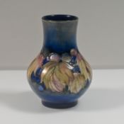 William Moorcroft, a salt glazed leaf & berry design vase, circa 1920's, height 13cm.