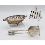 A small silver four division toast rack, a pair of asparagus servers and a pierced silver dish (3)