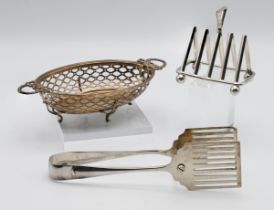 A small silver four division toast rack, a pair of asparagus servers and a pierced silver dish (3)